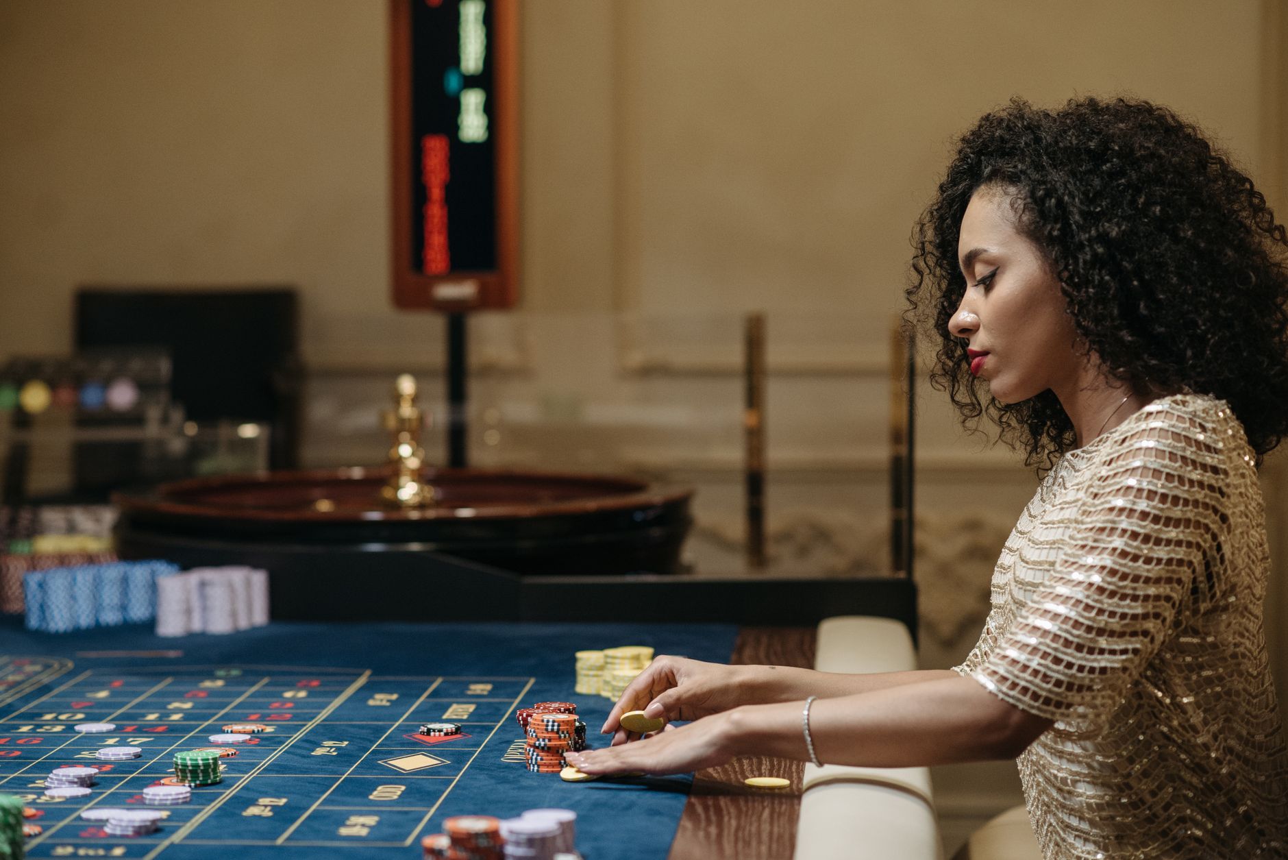 Stylish woman in a casino setting, playing roulette with stacks of chips. — Discover How Baccarat Combines Simple Rules with